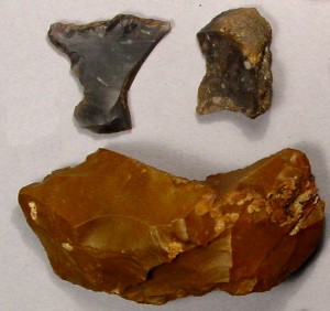 Strike-a-light stones for making fire, from the Daniels house. The black and gray ones were made from English flint ship-ballast cobbles, and the bottom one was made from a 2,000 year-old Native American stone tool of red Pennsylvania jasper stone. It may have been found by members of the Daniels family while they were working their fields - AHS, Inc., Storrs