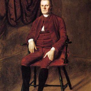 Painting of a man sitting in a chair. There is a drapery behind him. He is wearing a reddish brown suit from the 18th century