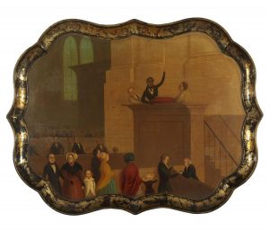 A decorative tray depicting a man at a pulpit surrounded by two other men. There are other people below in the pews.