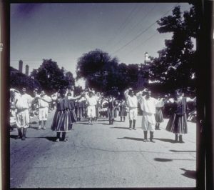 Array of people in a street as part of a parade