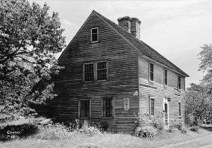 Black and white photo of a three story house.