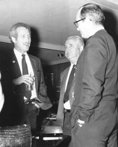 Three men in suits standing talking