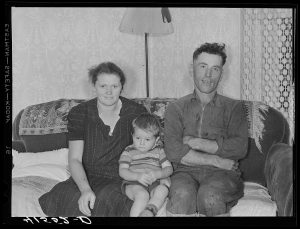 Woman, child, and man sitting on a couch