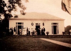 White building with several people standing in front 