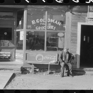 Man sitting on a bench in front of a storefront