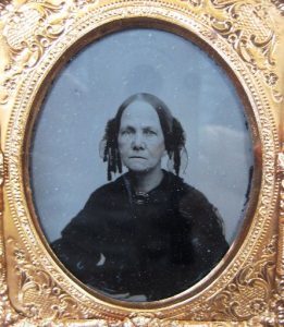 Portrait of a woman wearing dark clothing looking towards the camera