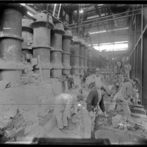 Industrial scene where several men are working at a manufactured gas plant