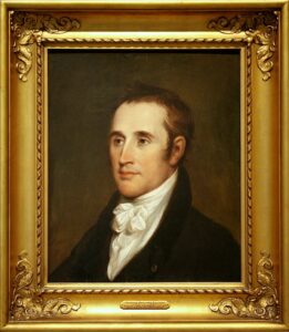 Profile portrait of a man surrounded by an ornate gold frame