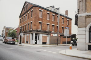 Photograph of a boarded up brick building