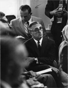 One man in the center of the frame with other people around him.